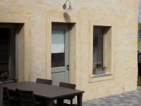 a table and chairs in front of a building with a door at Modern Holiday Home in Florenville with Garden in Chassepierre