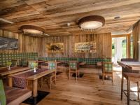 Un restaurante con paredes de madera y mesas y sillas. en Aktivhotel Gasteiner Einkehr, en Dorfgastein