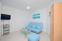 a living room with a blue couch and a table at Apartments Branislav in Rogoznica