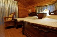 a bedroom with two beds in a log cabin at Sun Moon Lake Full House Resort in Yuchi