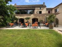 Un patio con mesas y sillas frente a un edificio. en Logis Hotel La Bergerie Hôtel 3 étoiles Restaurant savoureux, en Saint-Pierre-Lafeuille