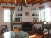 a living room with a table and a fireplace at Apartamentos Buganvilla in Villaluenga del Rosario