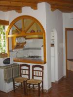 a kitchen with a counter and a table and chairs at Apartamentos Buganvilla in Villaluenga del Rosario