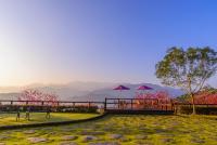 a park with benches and umbrellas with mountains in the background at Yilan Ya Lu Homestay in Datong