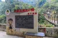 a sign with a painting on it next to a mountain at Dongpo Ti Lun Hotel in Xinyi
