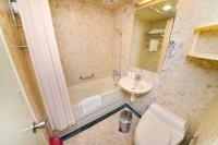 a bathroom with a tub and a toilet and a sink at Dongpo Ti Lun Hotel in Xinyi