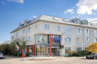 Un gran edificio blanco en una calle con semáforo. en Hotel Stuttgart Sindelfingen City by Tulip Inn, en Sindelfingen