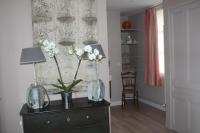 a vase of flowers on a dresser in a room at Logis Saint-Léonard in Honfleur