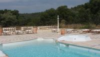 a swimming pool with tables and chairs and a fence at Bastide De Mazan in Riez