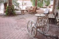 einer Gruppe von Bänken und Tischen und einem holzförmigen Rad in der Unterkunft Williams House in Eilat