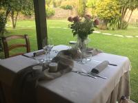 uma mesa com uma toalha de mesa branca e um vaso de flores em Relais Borgofasceo em Ortovero