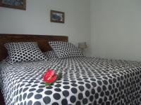 a red rose sitting on a black and white bed at Le four à pain in Saint-Philippe
