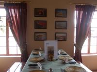 a table with plates of food on it in a room with windows at Huis KlipdriftSelf Catering &B&B in Hentiesbaai