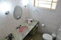 a bathroom with a sink and a mirror and a toilet at Pousada Sino dos Ventos in Campos do Jordão