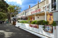 a building on a street with people walking in front of it at Commodores Lodge in Russell