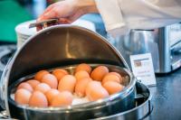 a person is cooking eggs in a pan at Hotel Artemis Amsterdam in Amsterdam