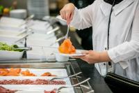 a chef is holding a plate of food at Hotel Artemis Amsterdam in Amsterdam