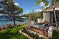 ein Haus mit einer Terrasse mit Blick auf das Wasser in der Unterkunft Villas Bellevue Plava Laguna in Poreč