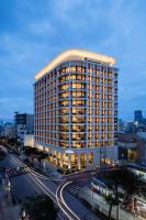 a large building with a lit up top on a city street at JR Kyushu Hotel Blossom Naha in Naha