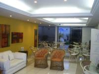 a living room with a couch and chairs and tables at Pousada Boulevard in Cabo Frio