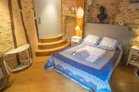 Un dormitorio con una cama con un edredón azul. en Le Compostelle de Conques, en Conques-en-Rouergue