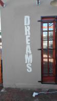 a white building with a door and a sign on it at Dreams in Beaufort West