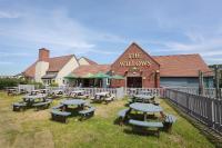 un grupo de mesas de picnic frente a un edificio en Willows, Blackburn by Marston&#39;s Inn, en Blackburn