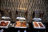 quatro bandejas de comida sobre uma mesa com pratos de comida em Royal Canaan Nairobi Hotel em Nairobi