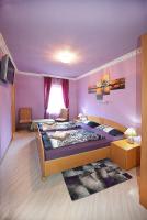 a bedroom with a large bed with purple walls at Pension zum Saale Blick in Bad Kissingen