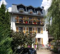 a white building with flower boxes on the balconies at Hotel Du Clocher in Chamonix