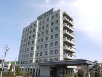 Un edificio alto y blanco con un cartel. en Hotel Route-Inn Nakatsugawa Inter, en Nakatsugawa