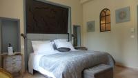 a bedroom with a large bed with a wooden headboard at Bastide De Mazan in Riez
