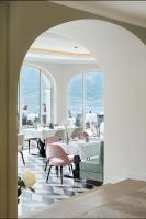 Un comedor con mesas blancas y sillas rosas. en Das Tegernsee, en Tegernsee