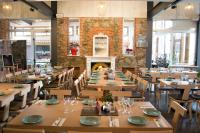 una sala da pranzo con tavoli e sedie e un camino di Farmakas Living a Pharmakas