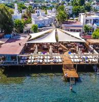 een dok met een tent en stoelen in het water bij Art Suites Hotel in Yalıkavak