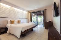 a bedroom with a large white bed and a television at Sarikantang Resort & Spa, Koh Phangan in Haad Rin