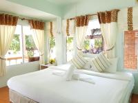 a bedroom with two large white beds with windows at Nice Sea Resort in Srithanu