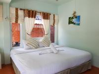 a bedroom with a large white bed with a window at Nice Sea Resort in Srithanu