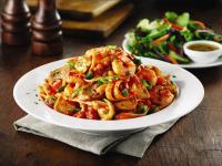 a plate of pasta on a table with a salad at Americana Waterpark Resort & Spa in Niagara Falls