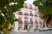un edificio rosa con un cartel delante en Olympos Hotel, en Komotiní