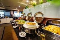 a buffet line with bowls of food and plates of food at Cambridge Tainan Hotel in Tainan