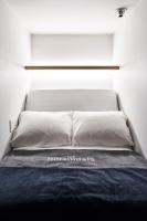 a bed in a room with a white wall at The Millennials Kyoto in Kyoto