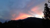 a sunset with a rainbow in the sky over a mountain at Ti Siang B&amp;B in Ren&#39;ai