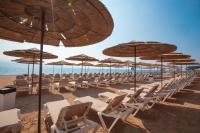 eine Reihe von Stühlen und Sonnenschirmen an einem Strand in der Unterkunft U Coral Beach Club Eilat – Ultra All inclusive in Eilat