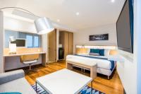 ブエナベントゥラにあるCosmos Pacifico Hotelのベッドと机があるホテルの部屋