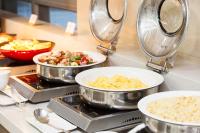 a kitchen with three pans of food on a counter at Ramada by Wyndham Jeju City Hall in Jeju