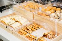 a buffet of bread and pastries in plastic containers at Ramada by Wyndham Jeju City Hall in Jeju