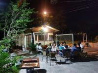 a group of people sitting at tables in a yard at night at Song Youf Hostel in Zhongpu