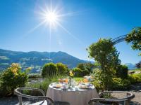 una mesa y sillas con vistas a las montañas en Gartenhotel Crystal - 4 Sterne Superior, en Fügen