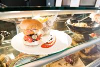 Un sándwich y papas fritas en un plato en una vitrina en Novotel Lille Aéroport, en Lesquin